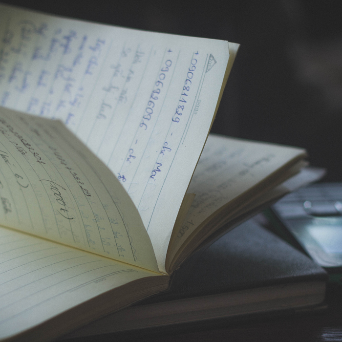 Notebook on a table next to a cellphone