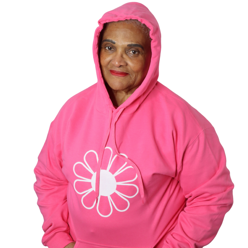 Woman wearing a pink hoodie with a white flower design on a white background