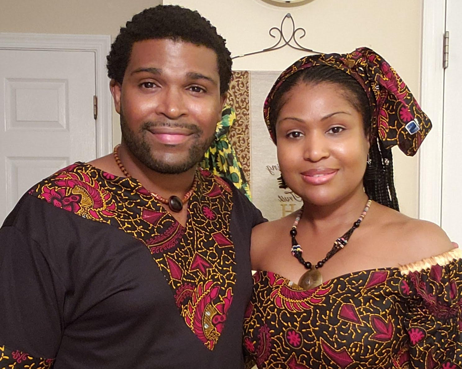 The founders of the Light Providers are wearing traditional African attire as they stand indoors.