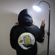 Model shown looking to the side, wearing a black zip hoodie featuring The Light Providers logo patch on the chest and We B...