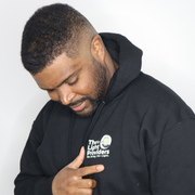 Model shown with arms crossed, wearing a black zip hoodie featuring The Light Providers logo patch on the chest and We Bri...