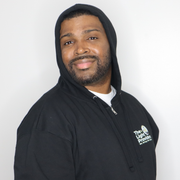 Model shown close up, wearing a black zip hoodie featuring The Light Providers logo patch on the chest and We Bring the Li...