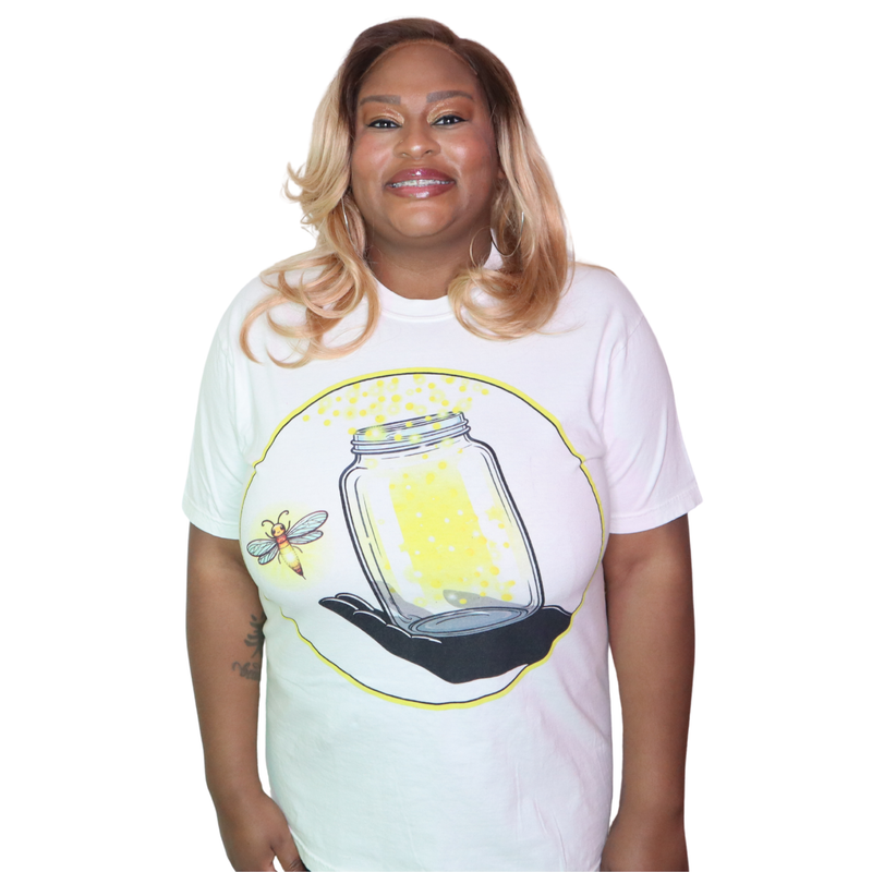 Model shown in a detail view of the print, wearing a garment dyed t-shirt featuring The Light Providers logo and firefly j...