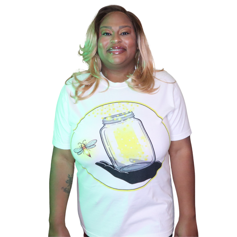 Model shown close up, wearing a garment dyed t-shirt featuring The Light Providers logo and firefly jar graphic in white o...