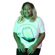 Model shown looking to the side, wearing a garment dyed t-shirt featuring The Light Providers logo and firefly jar graphic...