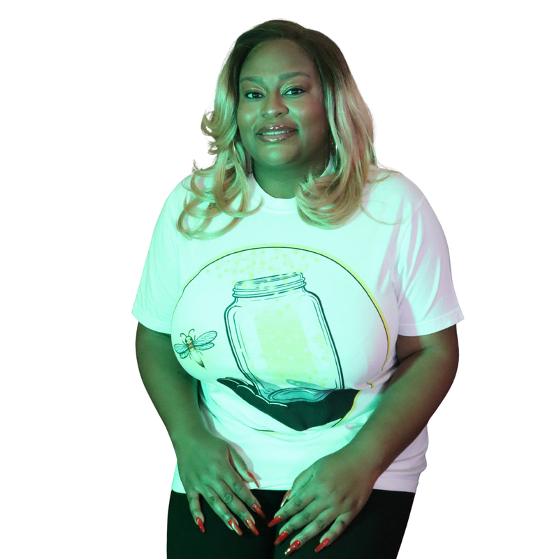 Model shown looking to the side, wearing a garment dyed t-shirt featuring The Light Providers logo and firefly jar graphic...