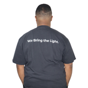 Model shown with hand on hip, wearing a garment dyed t-shirt featuring a scattered firefly light pattern above The Light P...