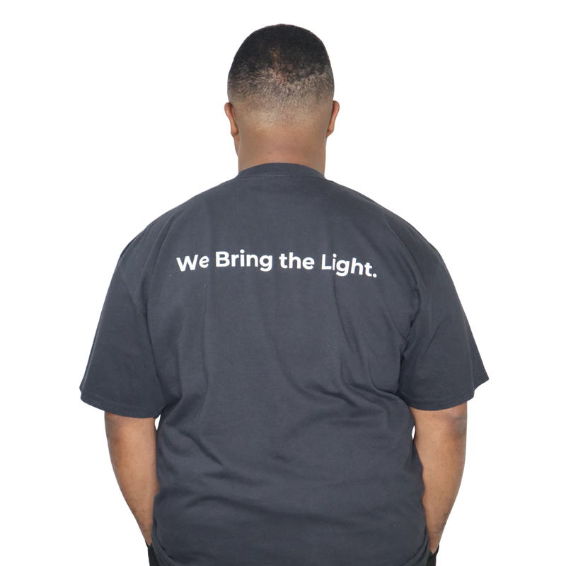 Model shown with hand on hip, wearing a garment dyed t-shirt featuring a scattered firefly light pattern above The Light P...