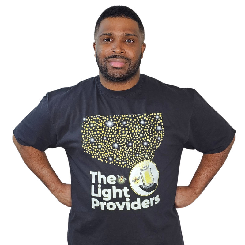 Model shown in side profile, wearing a garment dyed t-shirt featuring a scattered firefly light pattern above The Light Pr...