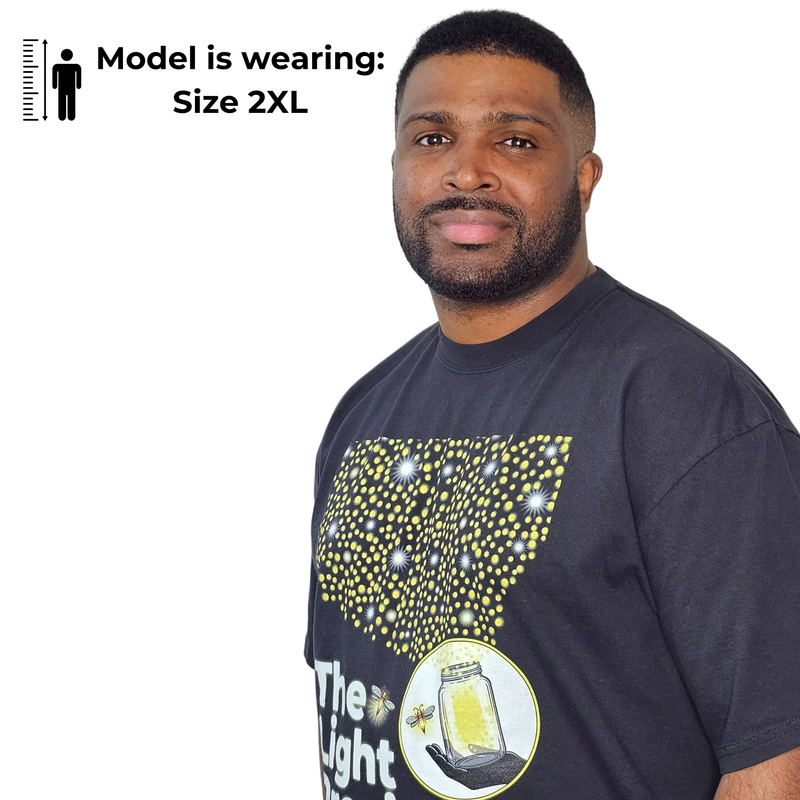 Model shown close up, wearing a garment dyed t-shirt featuring a scattered firefly light pattern above The Light Providers...