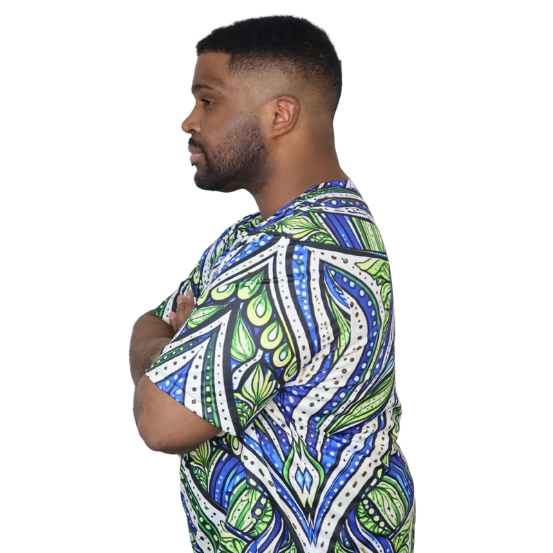 Model shown with hand on hip, wearing a t-shirt featuring an all over green white and blue Ankara style leaf pattern