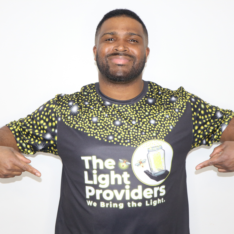 Model shown from the front, wearing a sports jersey featuring a scattered firefly light pattern with The Light Providers l...