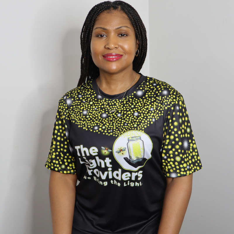 Model shown in side profile, wearing a sports jersey featuring a scattered firefly light pattern with The Light Providers ...