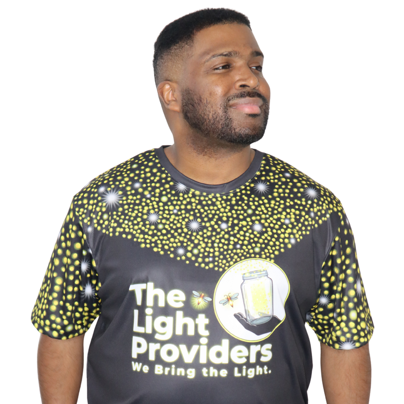 Model shown with hand on hip, wearing a sports jersey featuring a scattered firefly light pattern with The Light Providers...