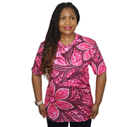Model shown looking to the side, wearing a sports jersey featuring an all over pink Ankara style floral pattern