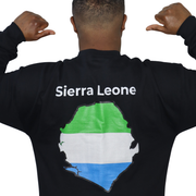 Person wearing a black crewneck sweatshirt featuring a Sierra Leone text and country outline map print in green white and ...
