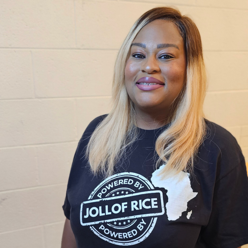 from the front, Powered By Jollof Rice stamp design with a white Africa map silhouette on a black t-shirt