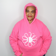 Woman wearing a bright pink hoodie with a white flower design on a plain background designed by The Light Providers
