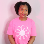 Woman wearing The Light Providers pink flower t-shirt on a pink background