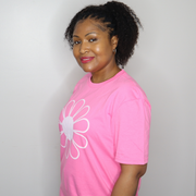 Woman wearing a pink t-shirt with a white flower design on a plain background