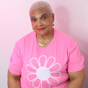 Woman wearing a pink t-shirt with a white flower design on a pink background