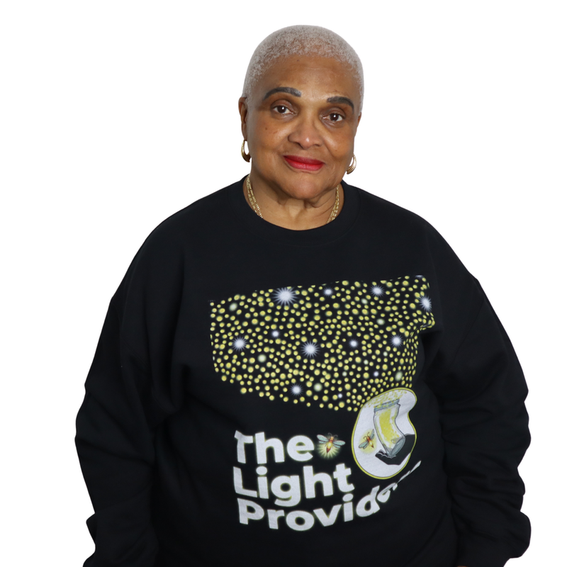 Woman wearing a black The Light Providers sweatshirt on a white background