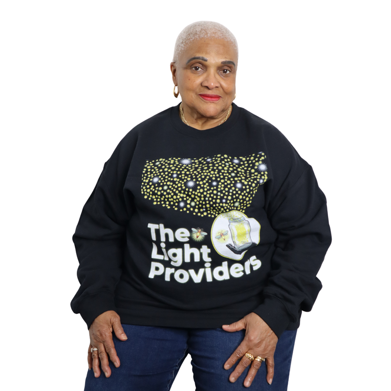 Person wearing a black sweatshirt with 'The Light Providers' text and design on a white background