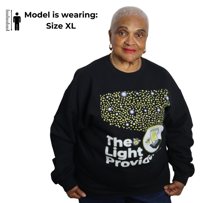 Woman wearing a black sweatshirt with a design and text, standing against a white background.