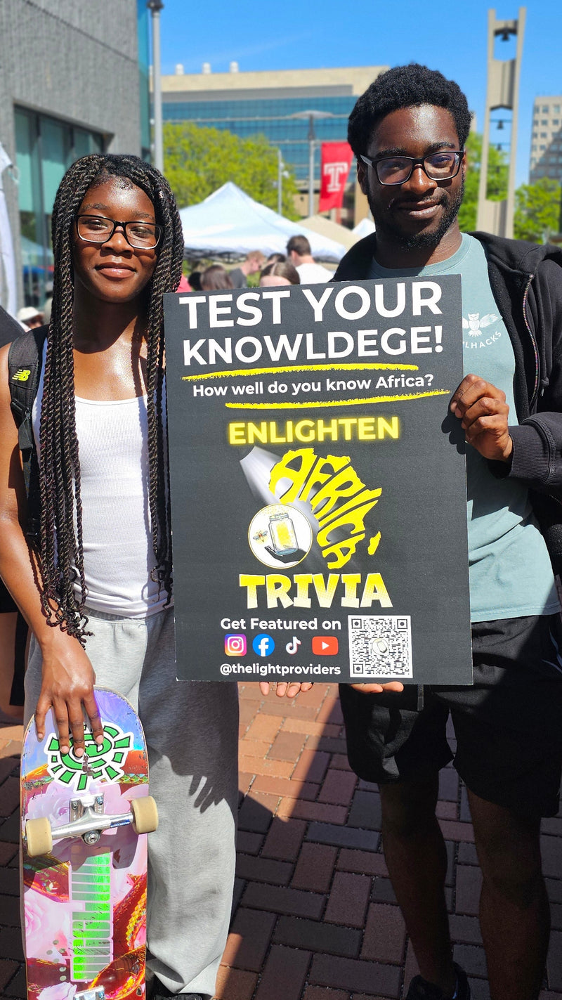 Two people holding Enlighten Africa Trivia board