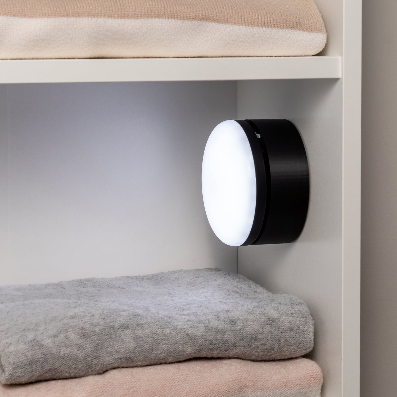 Black mount in use with a wireless light in a closet