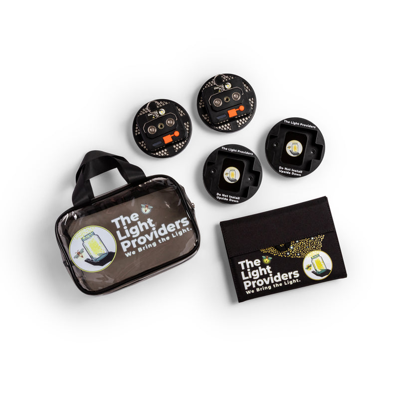 Clear utility bag, solar panel, two black mounts, two wireless lights showing back view