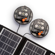 Two wireless light back view being charged by solar panel